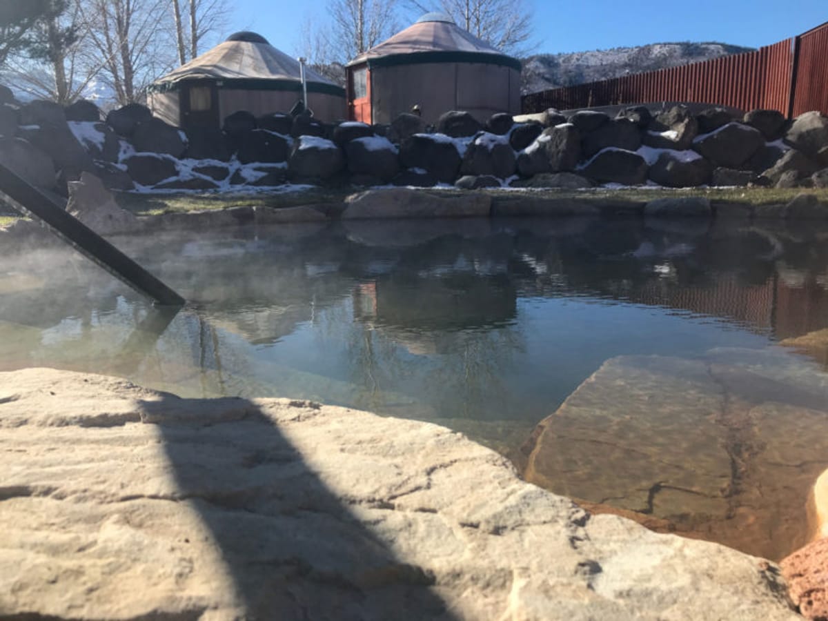 Clear water reflecting stone structures near a rocky shore.